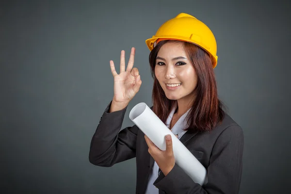 Asian engineer girl hold a blueprint show OK sign and smile — Stock Photo, Image