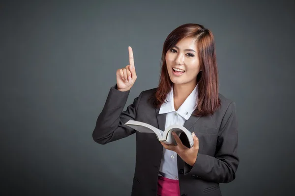 Asian business girl hold a book and point up — Stock Photo, Image