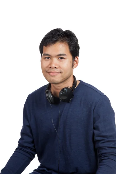 Asiatiska mannen leende med hörlurar på halsen — Stockfoto
