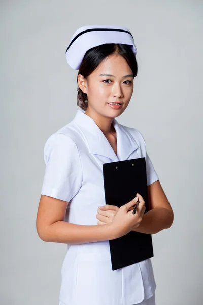 Junge asiatische Krankenschwester halten ein Klemmbrett — Stockfoto