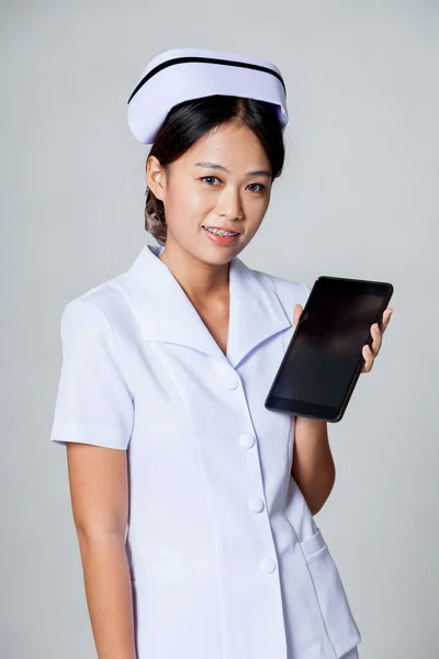 Jeune infirmière asiatique montrer un comprimé pc — Photo