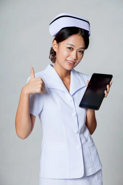 Young Asian nurse thumbs up with a tablet pc — Stock Photo, Image