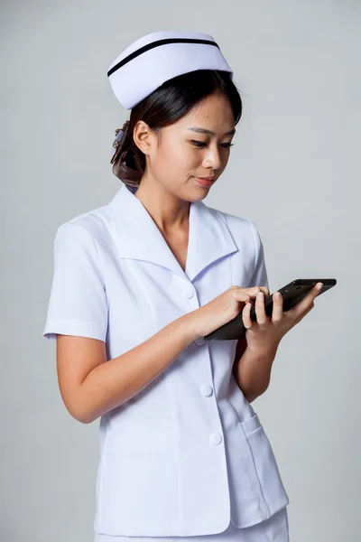 Joven enfermera asiática tocar una pantalla de PC tableta — Foto de Stock