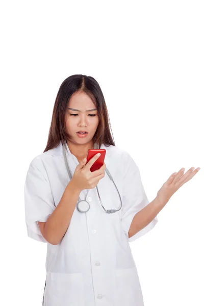 Asiático jovem médico mulher chateado com telefone móvel — Fotografia de Stock