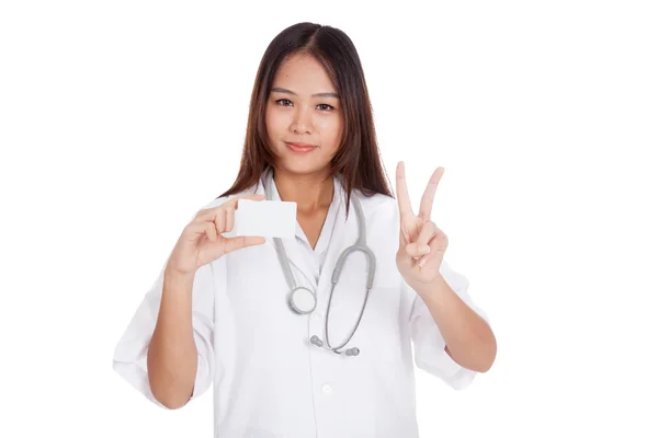 Asiatische junge Ärztin zeigt Siegeszeichen mit Blankokarte — Stockfoto