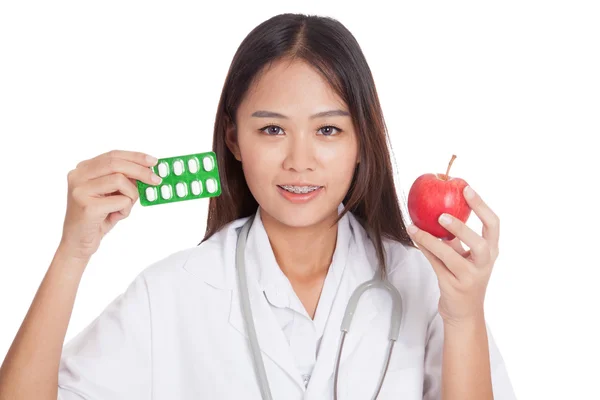 Young Asian female doctor with pills and apple — Stock Photo, Image