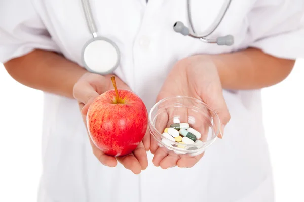 Läkaren håller medicin och apple — Stockfoto