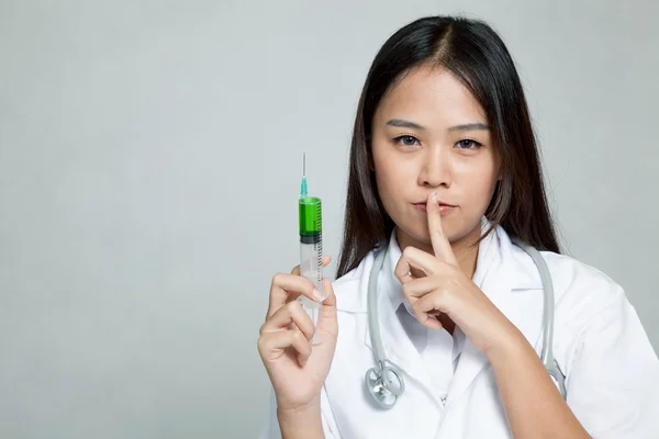 Jonge Aziatische vrouwelijke arts met spuit rustige teken weergeven — Stockfoto