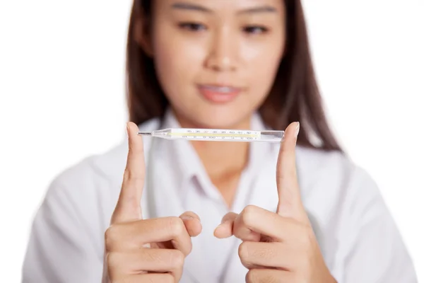 Giovane medico femminile asiatico con termometro concentrarsi sul termometro — Foto Stock