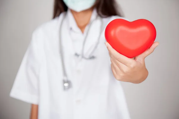 Asiática mujer médico con rojo corazón foco en el corazón —  Fotos de Stock