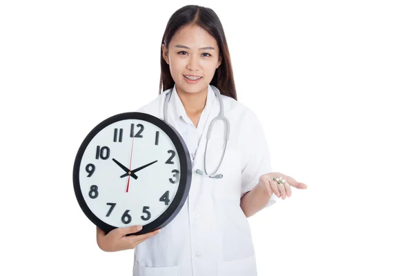 Jovem asiática médica sorrir com um relógio e pílulas na mão — Fotografia de Stock