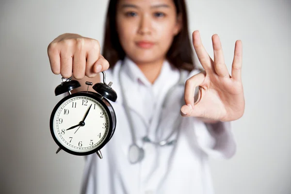 Jeune asiatique femme médecin montrer OK avec une horloge — Photo