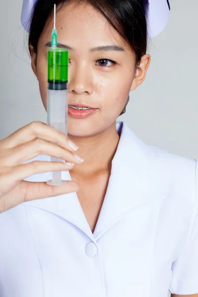 Young Asian nurse look at syringe — Stock Photo, Image