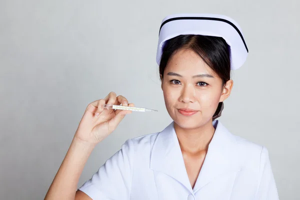 Jeune infirmière asiatique avec thermomètre — Photo
