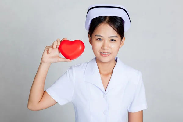 Joven asiática enfermera mostrar rojo corazón — Foto de Stock