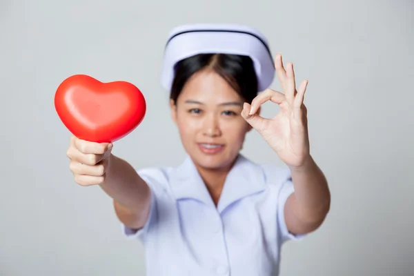 Young Asian nurse OK with red heart — Stock Photo, Image