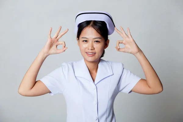 Junge asiatische Krankenschwester zeigen ok mit beiden Händen — Stockfoto