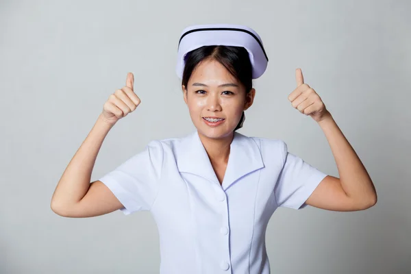 Joven asiática enfermera thumbs arriba con ambos manos — Foto de Stock
