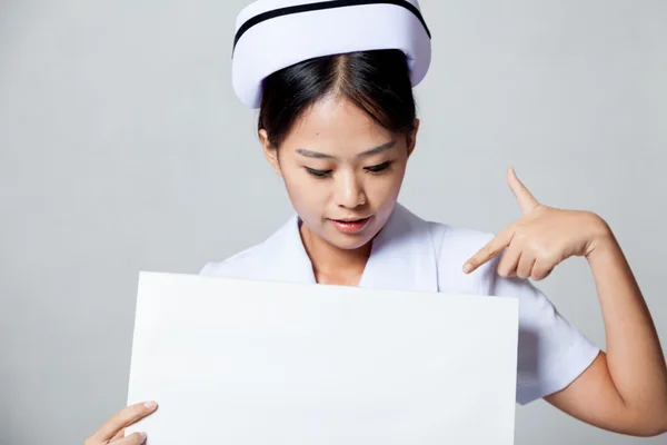 Young Asian nurse point down to blank sign — Stock Photo, Image