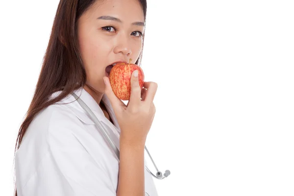 Nahaufnahme junge asiatische Ärztin beißt Apfel — Stockfoto