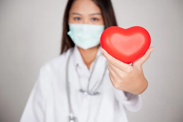 Jonge Aziatische vrouwelijke arts met rood hart — Stockfoto