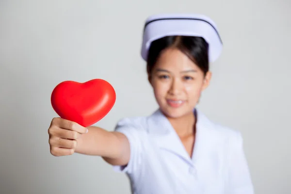 Junge asiatische Krankenschwester zeigen rotes Herz Fokus auf das Herz — Stockfoto