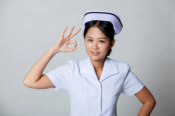 Junge asiatische Krankenschwester zeigen ok Zeichen — Stockfoto