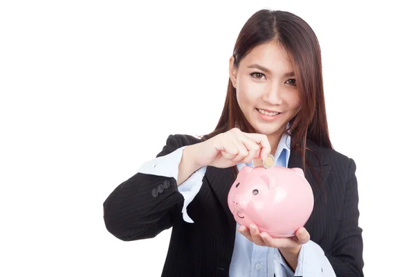 Jonge Aziatische zakenvrouw met een munt en piggy bank — Stockfoto