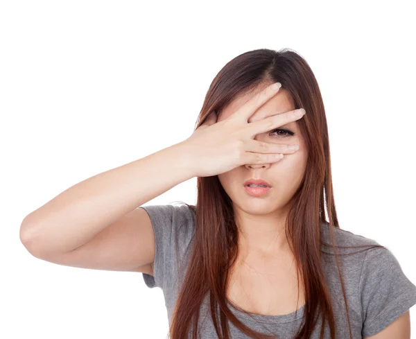 Joven mujer asiática espiando a través de sus dedos — Foto de Stock
