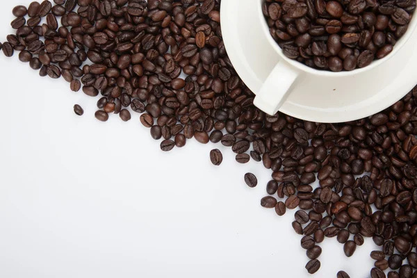 Granos de café tostados con una taza —  Fotos de Stock