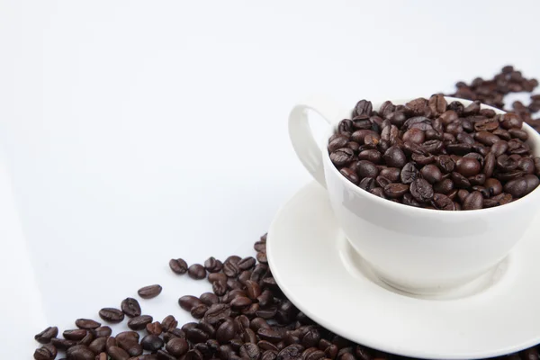 Granos de café tostados con una taza —  Fotos de Stock