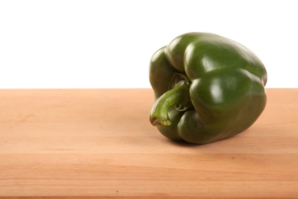 Green bell pepper on wooden table — Stock Photo, Image