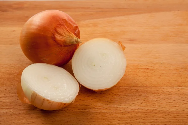 Uien op houten tafel — Stockfoto