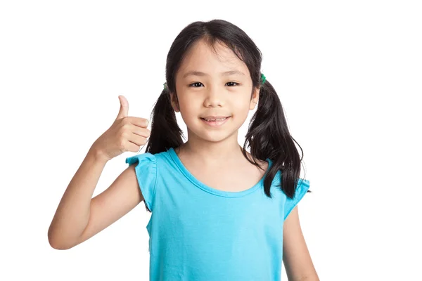 Маленькая азиатская девочка улыбается показывая большие пальцы вверх — стоковое фото
