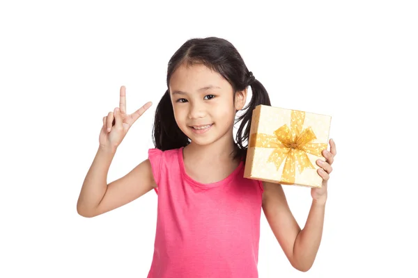 Kleine asiatische Mädchen mit Geschenk-Box zeigen Siegeszeichen — Stockfoto