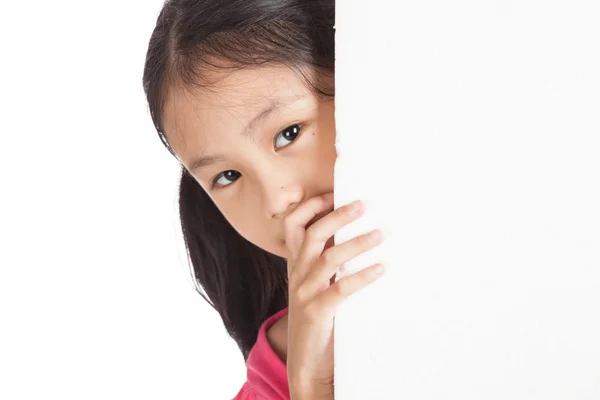 Pequeña chica asiática mirando detrás de una pizarra blanca — Foto de Stock