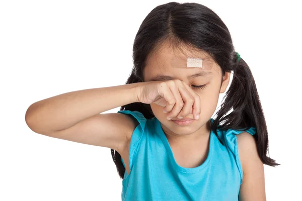 Aziatische meisje huilen met pleister op voorhoofd — Stockfoto