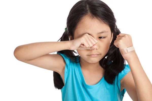 Pequeña chica asiática llorando con vendaje en su mano — Foto de Stock