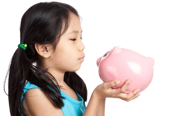 Little asian girl kiss a piggy bank — Stock Photo, Image
