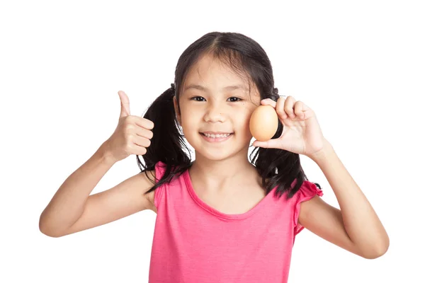 Aziatische meisje duimen omhoog met een ei in de hand — Stockfoto