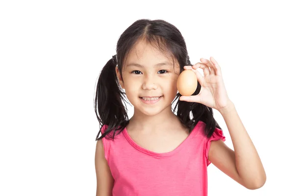 Kleine asiatische Mädchen lächeln mit einem Ei in der Hand — Stockfoto