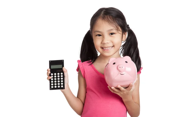 Piccola ragazza asiatica con una calcolatrice e salvadanaio Fotografia Stock