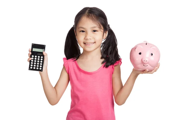 Piccola ragazza asiatica con una calcolatrice e salvadanaio Fotografia Stock