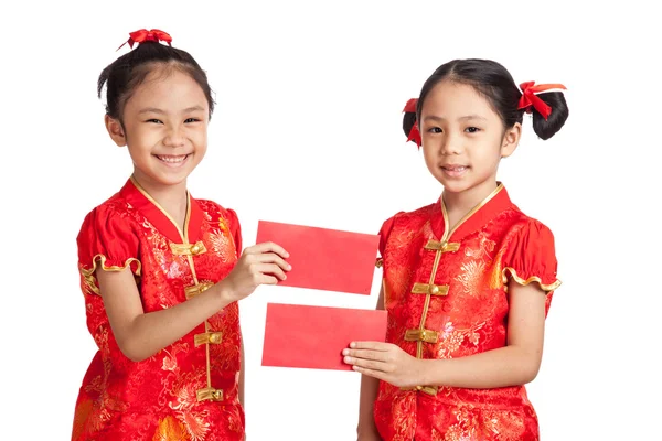 Asiático gêmeos meninas em chinês cheongsam vestido com envelope vermelho — Fotografia de Stock