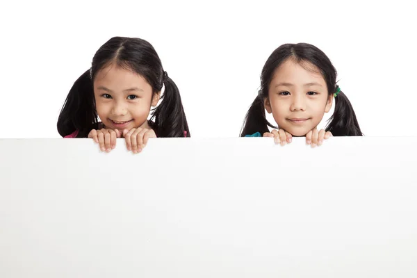 Happy Asian twins girls  behind white blank banner — Stock Photo, Image