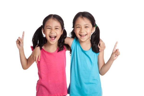 Glücklich asiatische Zwillinge Mädchen lächeln zeigen nach oben lizenzfreie Stockbilder
