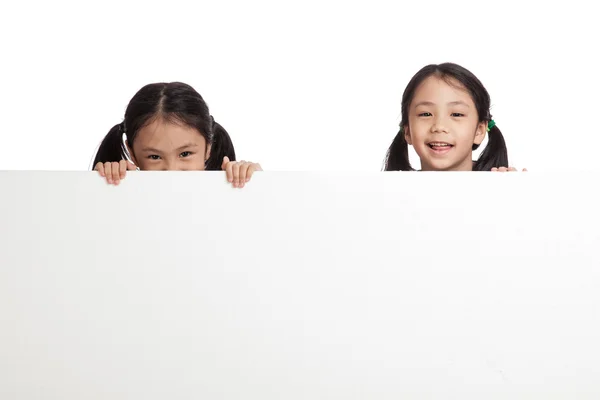 Happy Asian twins girls  behind white blank banner — Stock Photo, Image