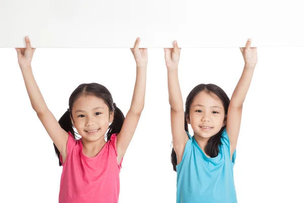 Feliz Asiático gemelos niñas con blanco banner en blanco sobre la cabeza — Foto de Stock