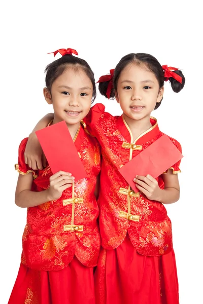 Asiático gemelos niñas en chino cheongsam vestido con sobres rojos — Foto de Stock