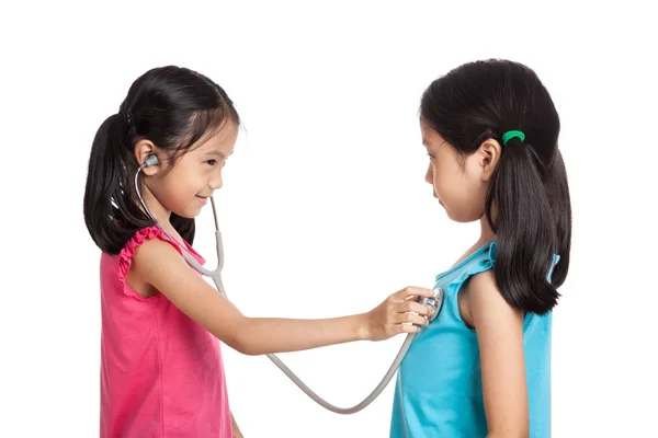快乐亚洲双胞胎女孩用听诊器 — 图库照片